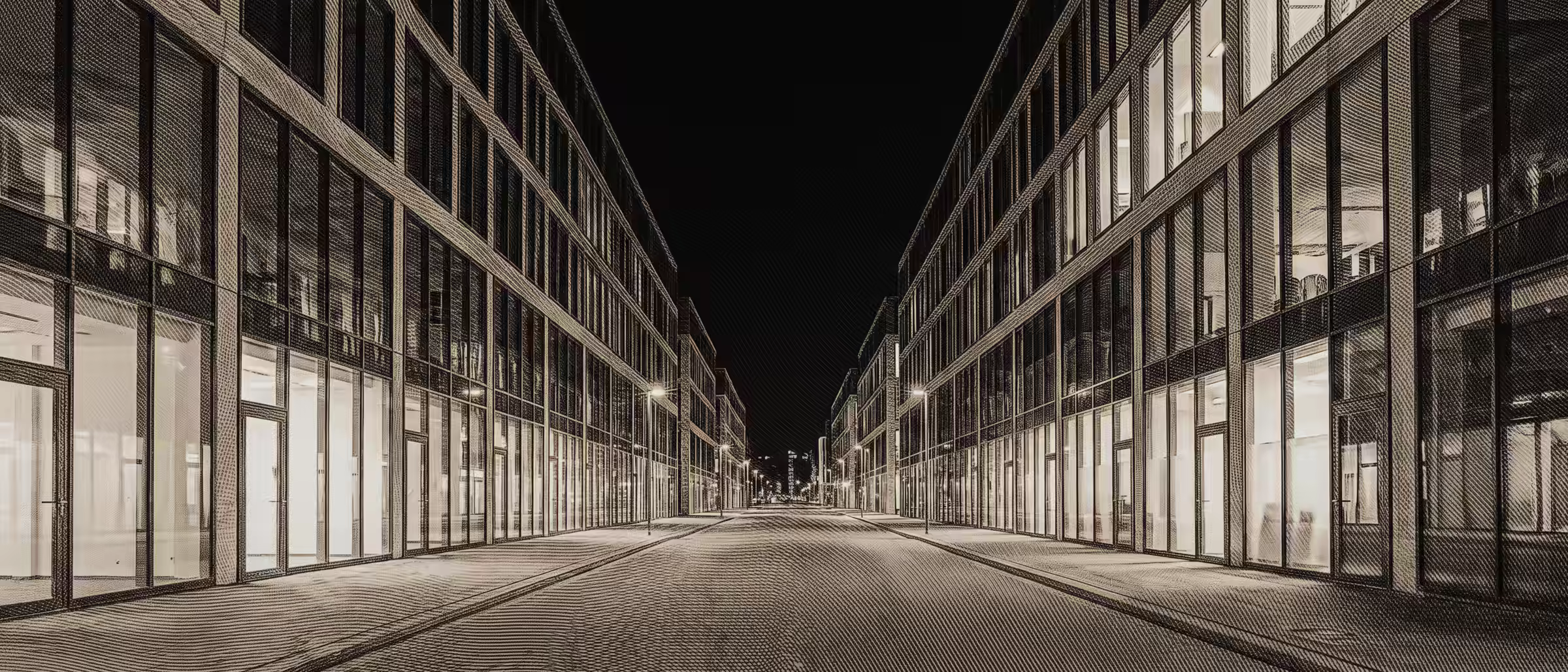 Una avenida de noche con muchas oficinas iguales a ambos lados, todas con la luz encendida